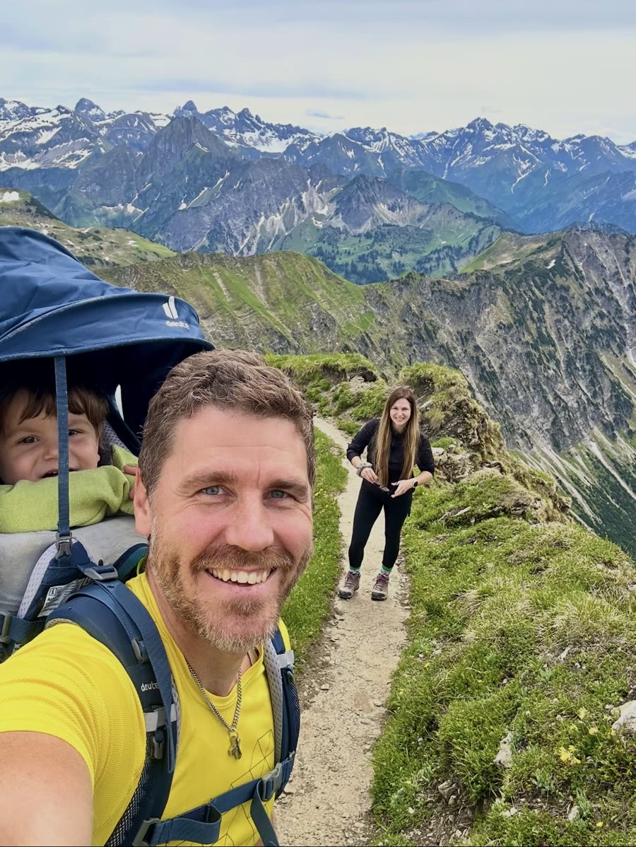 Sébastien Schmitt mit Familie bei einer Bergwanderung, im Hintergrund schneebedeckte Gipfel
